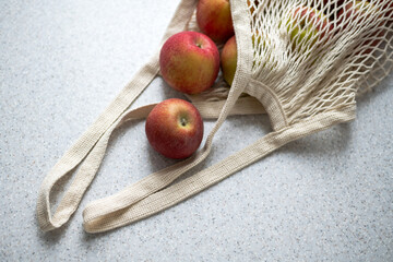 Eco friendly hand bag with ripe apples on the table