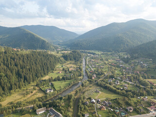 Obraz premium Green mountains of Ukrainian Carpathians in summer. Coniferous trees on the slopes. Aerial drone view.