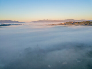 Sunrise over the fog in the Ukrainian Carpathians. Aerial drone view.