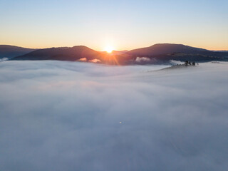 Sunrise over the fog in the Ukrainian Carpathians. Aerial drone view.