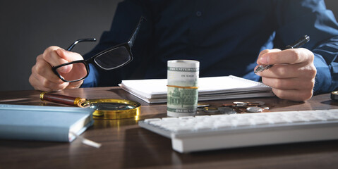 Businessman working at office. Dollar money on the desk. Finance. Investment