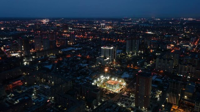 Time-lapse of the night city. Aerial photography from a great height. The city is covered with snow. Automobile traffic.