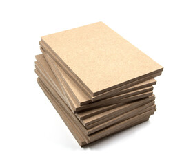 A pile of planks of raw MDF cut in a rectangular shape, of identical dimensions.