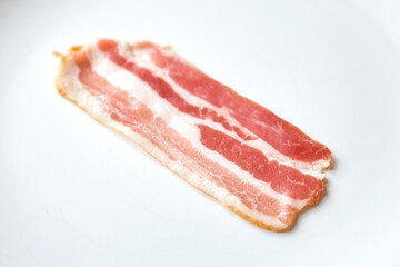 Bacon strip, raw smoked pork meat slice isolated on white