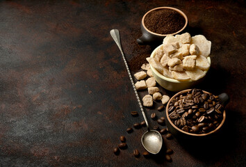 Bowls with dried ginger, brown lump and granulated sugar, coffee beans and ground coffee as...