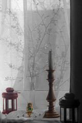 Shadow drawing from a branch of cherry on the window.Household items created an interior composition on the window.Owl, icon lamp, sticks incense, light from the window.