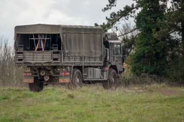 army logistics lorry vehicle truck driving along a dirt track 