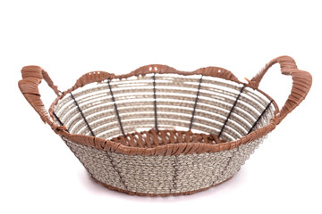 Obraz premium knitted basket with metal inserts and handles on a white background