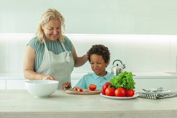 Healthy eating concept. Cute woman and child cooking in white kitchen