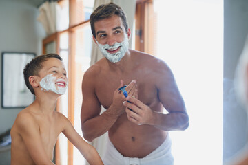 And soon...all the hair will be gone. Cropped shot of a handsome young man teaching his son how to shave in the bathroom.