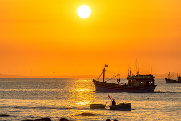 Fototapeta premium Sunset landscape when fishing boats out to sea to harvest fish end the day.