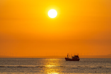 Obraz premium Sunset landscape when fishing boats out to sea to harvest fish end the day.