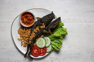 Lele Goreng Kremes. Popular street food, deep-fried catfish and topped with fried seasoned crispy...
