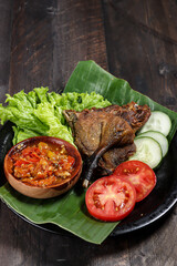 Bebek Goreng sambal bawang, deep fried duck served with sambal (garlic chilli sauce) and fresh vegetables.