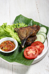 Bebek Goreng sambal bawang, deep fried duck served with sambal (garlic chilli sauce) and fresh vegetables.