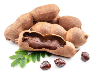 Ripe tamarind fruit, leaves and some tamarind seeds isolated on white background.