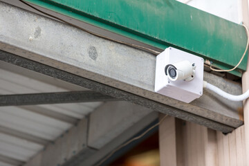 Security CCTV camera surveillance system outdoor of house. A blurred night city scape background. Modern CCTV camera on a wall. Equipment system service for safety life or asset.	