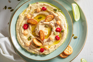 Vegan and traditional hummus with round crackers and olives.
