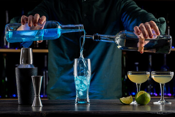 Bartender's hands serving cocktails on bar counter in a restaurant, pub. Mixed drinks. Alcoholic cooler beverage at nightclub on dark background
