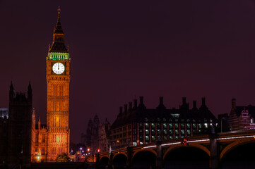 Fototapeta na wymiar Big Ben of the Houses of Parliament London England UK at night striking midnight on new year's eve on Westminster Bridge which is a popular city landmark, stock photo with copy space