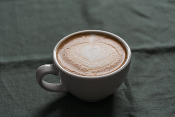 Fresh flat white coffee in white cup on linen cloth