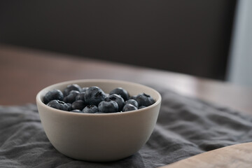Fototapeta na wymiar Fresh washed blueberries in white bowl on wood table