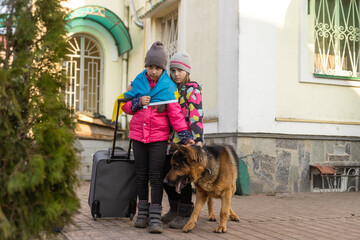 Ukraine military migration. two little girls with a suitcase. Flag of Ukraine, help. Crisis,...