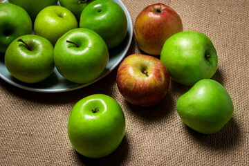 The apples lie on the burlap. Different varieties of apples. ripe fruit