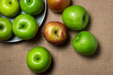 The apples lie on the burlap. Different varieties of apples. ripe fruit