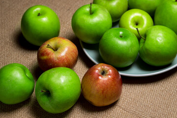The apples lie on the burlap. Different varieties of apples. ripe fruit