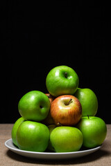 Fresh apples on a black background. Different varieties of apples. ripe fruit
