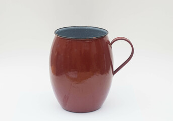 Vintage brown enameled metal jug with handle isolated