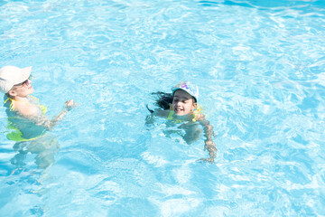 Beautiful woman with her daughter in swimming pool