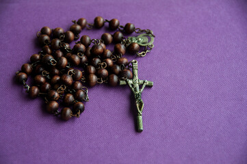 Holy Rosary on purple cover background. Religious and copy space concept
