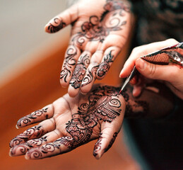 When words cant express, try henna. Cropped shot of an unrecognizable woman getting henna applied to her hands in preparation for her wedding.