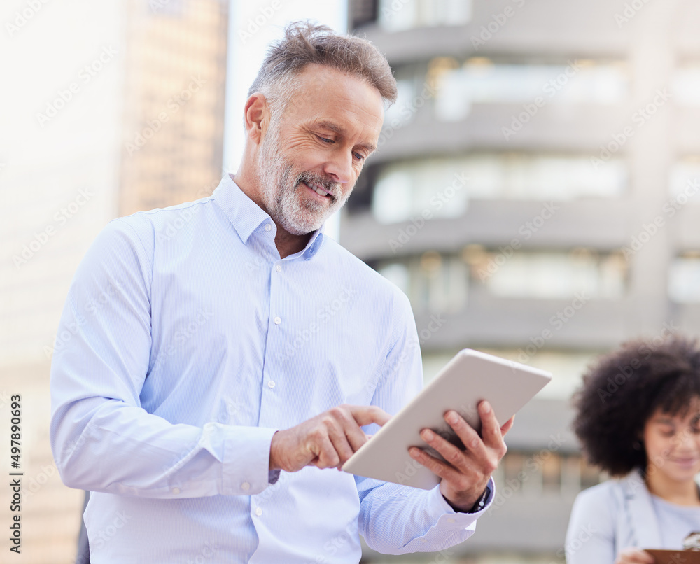 Aufkleber I can see what every team member is working on. Shot of a handsome mature businessman standing outside and using a digital tablet while his colleague stands behind him.