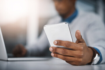 Planning out his day the smart way. Closeup shot of an unrecognizable businessman using a cellphone in an office.