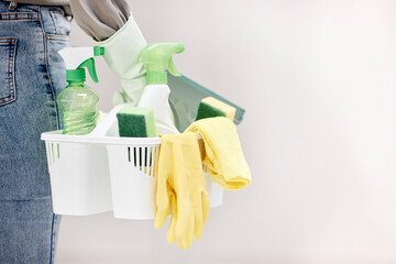 Everything I need in one basket. Shot of a woman holding a basket of cleaning supplies against a...