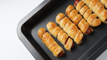 Sausage buns. Soft baked bun (dough )stuffed with sausage for fast food breakfast or coffee break. Sausage  roll, (hot dog).