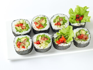 vegetable vegetarian sushi roll with vegetables in nori on a white plate isolated