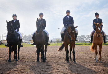They share a love of horse riding. Full length shot of a group of attractive young female jockeys...