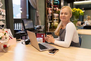 friendly flower shop owner working at the computer with a smile on her face