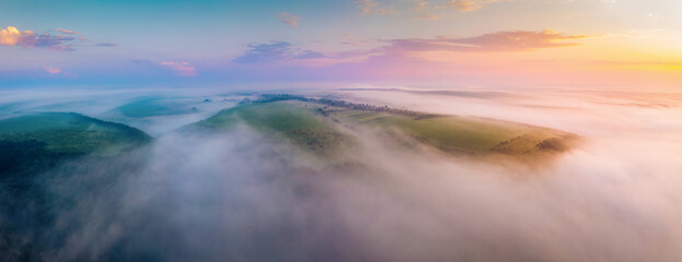 Gorgeous scene of hills in the fog from a bird's eye view. Aerial photography, drone shot.