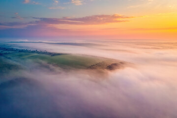 Gorgeous scene of hills in the fog from a bird's eye view. Aerial photography, drone shot.
