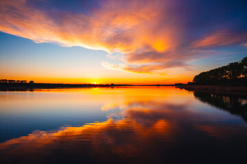 Obraz premium Fantastic view of the sundown over water surface on a cozy lake.