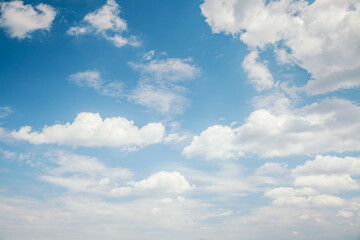 Naklejka na ściany i meble Blue sky background with white fluffy clouds in the fresh sunny day.