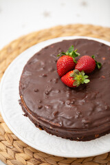 Fresh chocolate cake with organic strawberries on top.