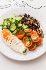 Cut fresh organic vegetables, tomatoes, cucumbers, dill and egg, with fried eggplant on a plate