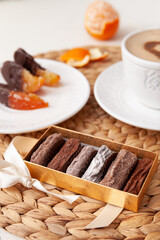 Sweet truffle dessert in cocoa powder with a cup of coffee and marmalade slices of orange in chocolate on the back background.