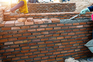 Close up of bricklayers building walls